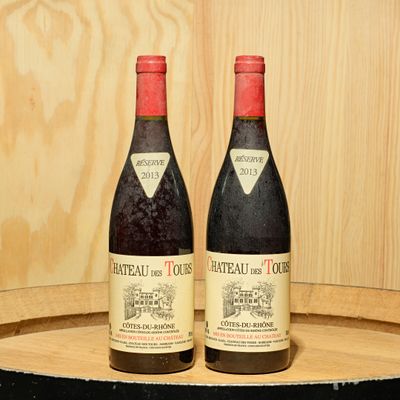 two bottles of wine sitting on top of a barrel