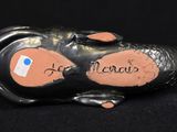 a figurine of a cat laying on a black surface