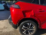 a red car that has been badly damaged and is parked in a parking lot