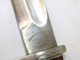 a close up of a knife on a white surface