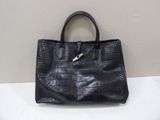 black leather handbag with a metal handle sitting on a white surface