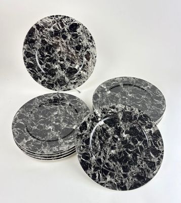 four black and white marble plates on a white background