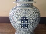 a blue and white vase with a lid sitting on a table