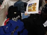 a pile of clothes and a book in a suitcase