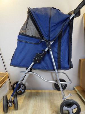a blue stroller that is sitting on a wooden floor