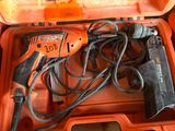 une boîte à outils orange contenant une perceuse filaire et d'autres outils