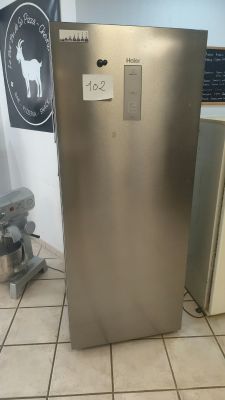 a stainless steel refrigerator in a kitchen with tile flooring