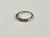a close up of a silver ring with pink stones on it