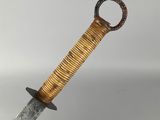 a close up of a knife with a wooden handle on a white surface