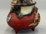 a red and black pot with a lid on a table