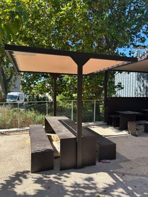 un banc et une table sous un auvent dans un parc