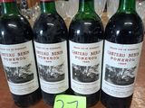 Quatre bouteilles de vin sont alignées sur une table, accompagnées d'une étiquette de prix