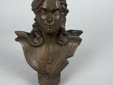 a bronze bust of a woman with long hair on a white background