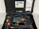 une photo d'une trousse à outils dans un coffret, avec un tuyau et un thermomètre numérique