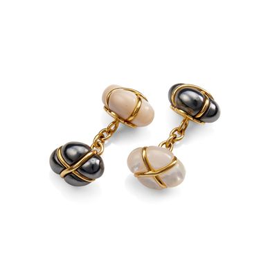a pair of black, white and gold earrings on a white background