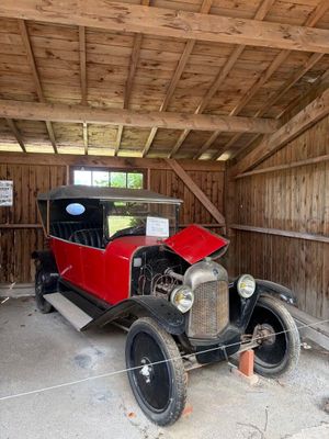 une vieille voiture dans un garage avec une pancarte sur la porte