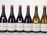 six bottles of wine are lined up in a row on a table