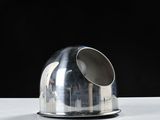 a silver object sitting on a table with a black background