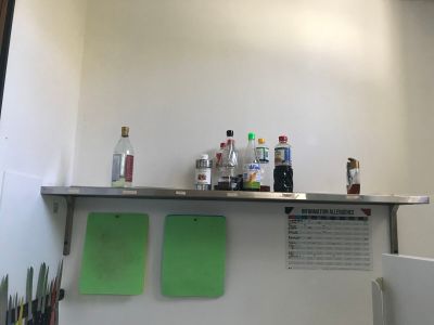 a counter that has a bunch of bottles on top of it