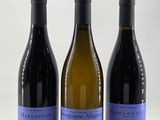 trois bouteilles de vin posées l'une à côté de l'autre sur une table