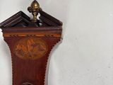 a clock hanging on the wall next to a ceiling fan