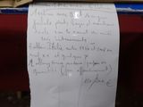 une feuille de papier avec une écriture dessus, posée sur une table