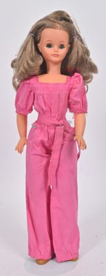 poupée Barbie vêtue d'une combinaison rose, d'un haut rose et de chaussures marron