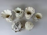 a group of small white vases sitting on a table