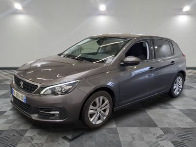 the grey car is parked on a checkered floor in the garage