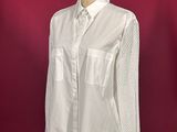 a white shirt on a mannequin stand against a red background
