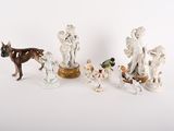 cinq figurines d'animaux et un chien posés sur une table