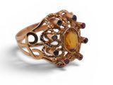 a close up of a gold ring with a yellow stone