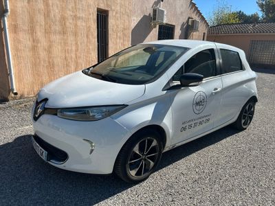 la petite voiture blanche est garée devant un bâtiment