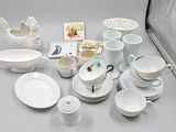 a lot of white dishes and cups on the table