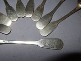six spoons and a spoon with a spoon rest on a table