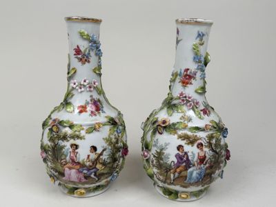 une paire de vases en porcelaine ornés de personnages peints, posés sur une table