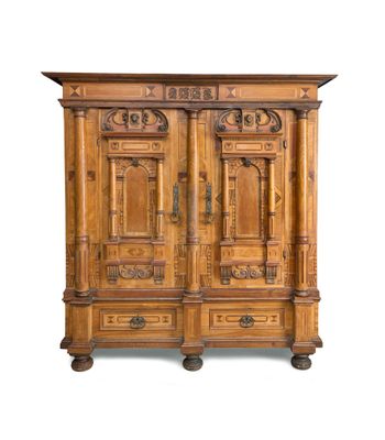 une vieille armoire en bois avec des gravures et des sculptures sur les portes
