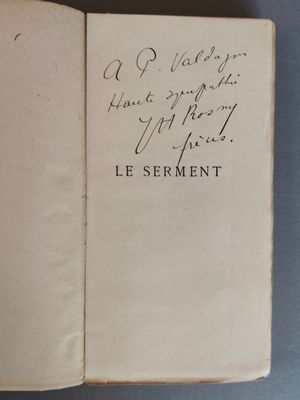 un livre ouvert avec une écriture dessus, posé sur une table