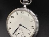 a close up of a pocket watch on a black surface