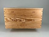 une boîte en bois sur laquelle est collée une étiquette de vin, posée sur une table