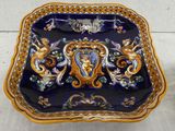 a blue and gold plate with a picture of a woman on it