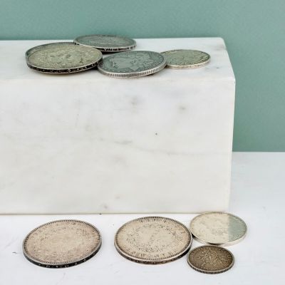 un bloc de marbre blanc sur lequel sont posées des pièces de monnaie