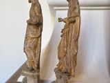 two statues of jesus and mary on top of a wooden table