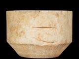 un bol en pierre sur lequel est sculpté un visage