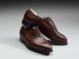 une paire de chaussures marron posée sur une surface blanche