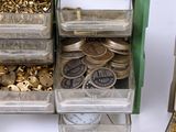 many bins of gold coins and coins in a green box