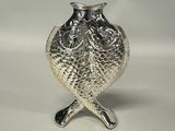 two silver spoons and a silver owl on a table