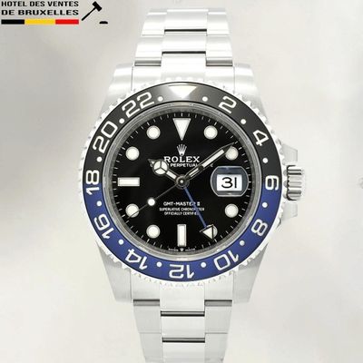 une montre Rolex avec un cadran noir et une lunette bleue