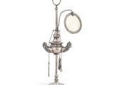 une lampe ancienne plaquée argent, munie d'un miroir et d'une chaîne qui en pend