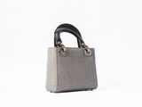 the small grey and black bag is sitting on a white surface